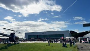 Helikopter und Menschen vor Hangar