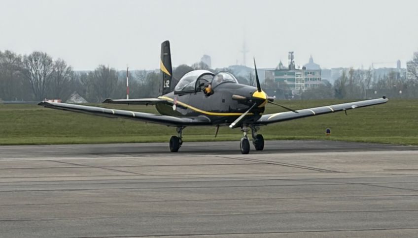 Black-yellow PC7 aircraft parking on the apron