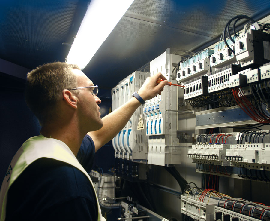 Elektroniker arbeitet an Schaltkasten.